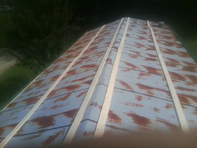Rusted metal roof panels with new wood purlins before replacement — Storm Damage Roof Repair in Mount Upton by Roofing Brothers